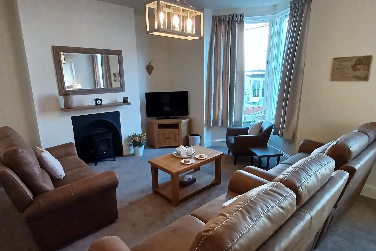 Bartley House lounge with leather sofas around a cast-iron fireplace and a bay window over the street