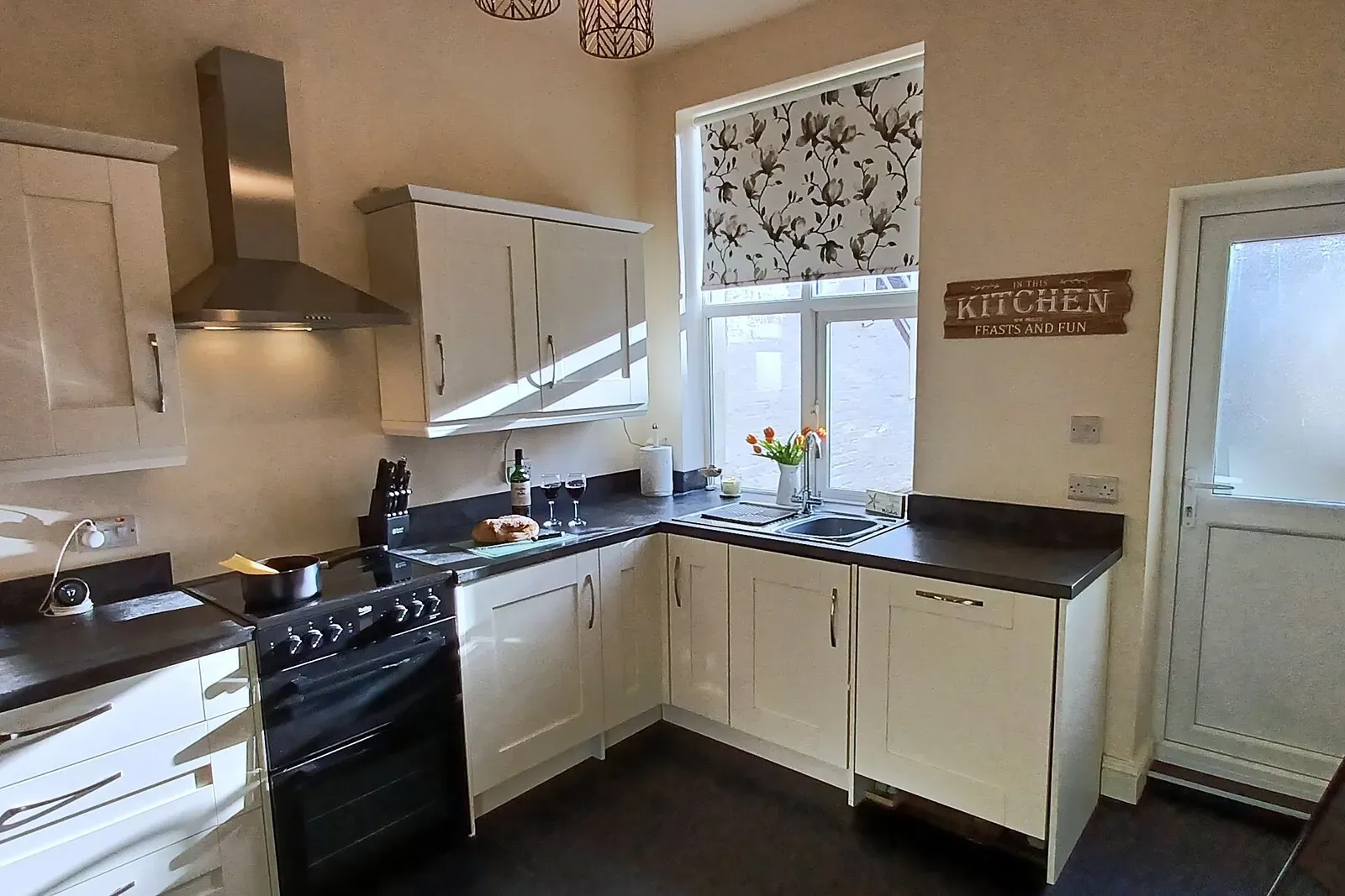 Bartley House kitchen with cream units, range cooker and a window over the courtyard