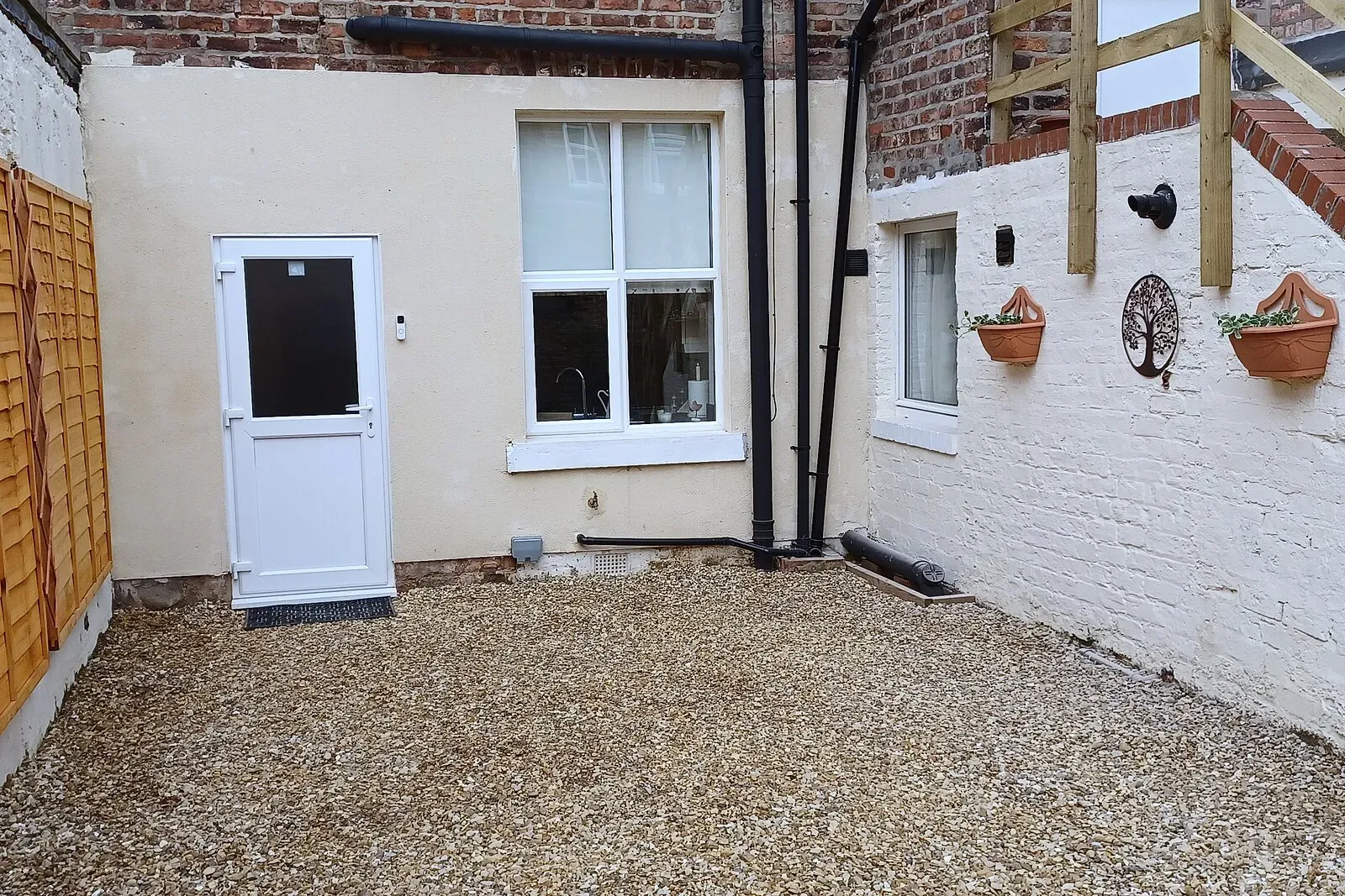 Enclosed gravelled rear courtyard with the back door into the kitchen